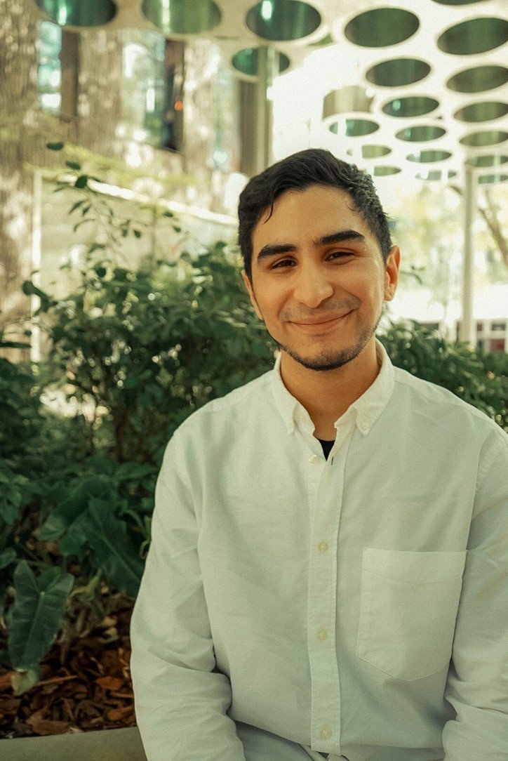 Nelson Gaitan smiling, in a white shirt outdoors